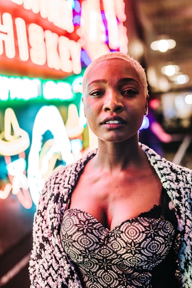 A vibrant model wearing a bold, patterned jacket from Nevaro Apparel's latest collection, standing confidently against a colorful urban backdrop.