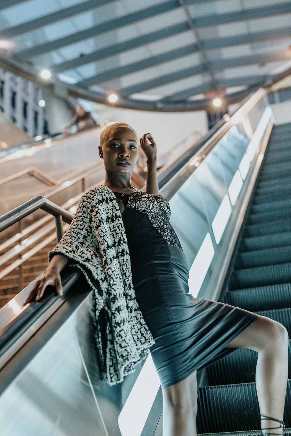 Photographie en contre-plongée d’une femme sur un escalator