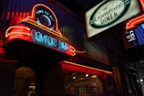 Classic roadside diner sign glowing bright at dusk on a quiet highway stretch