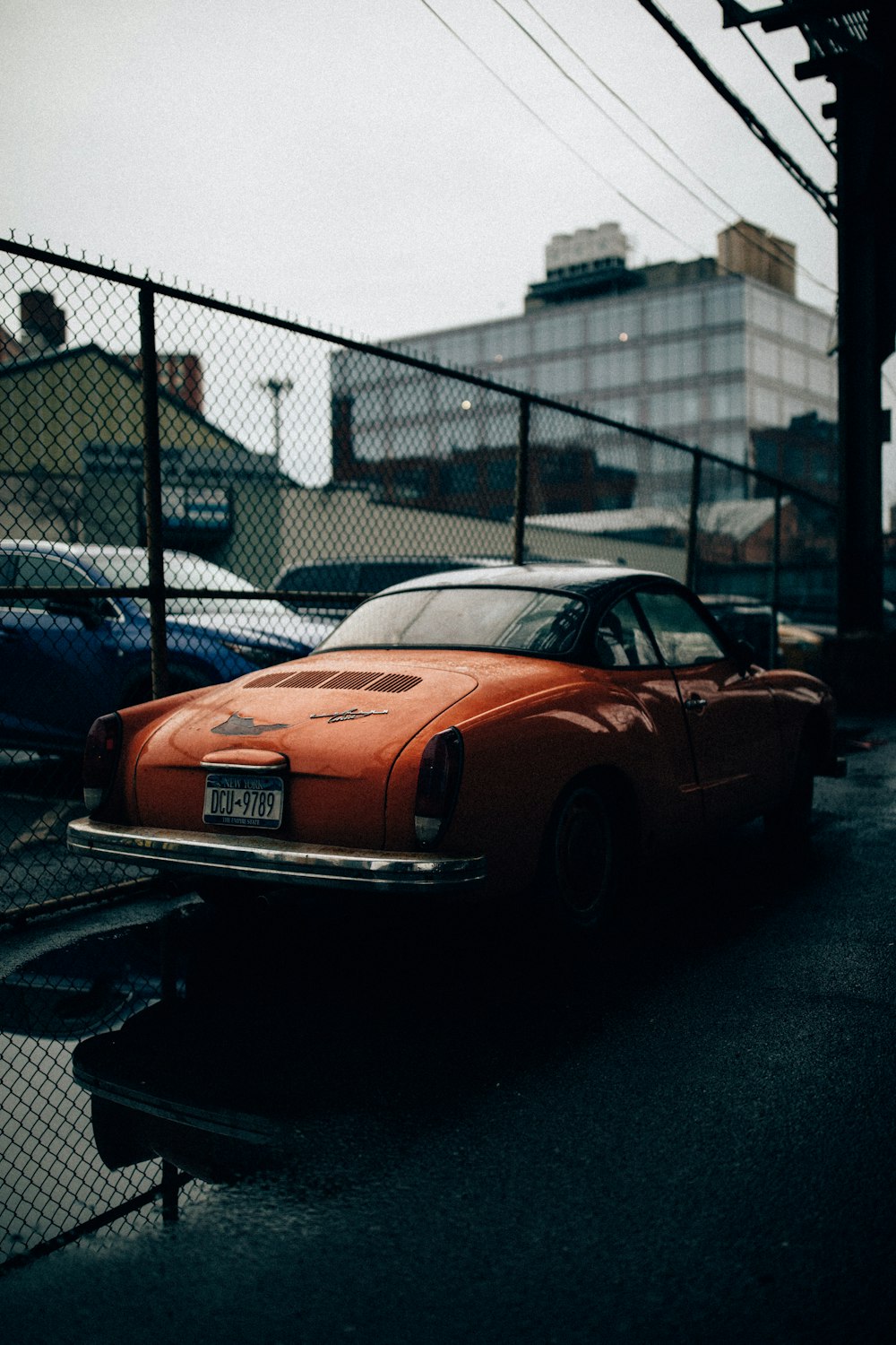 red sport coupe parked near the post