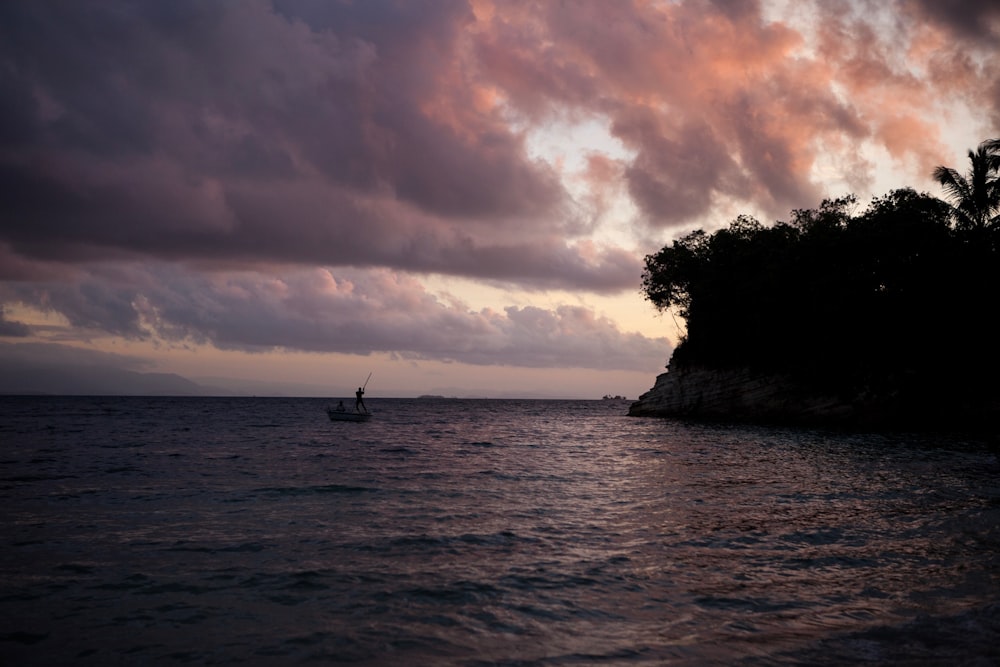 sail boat on body of water near island