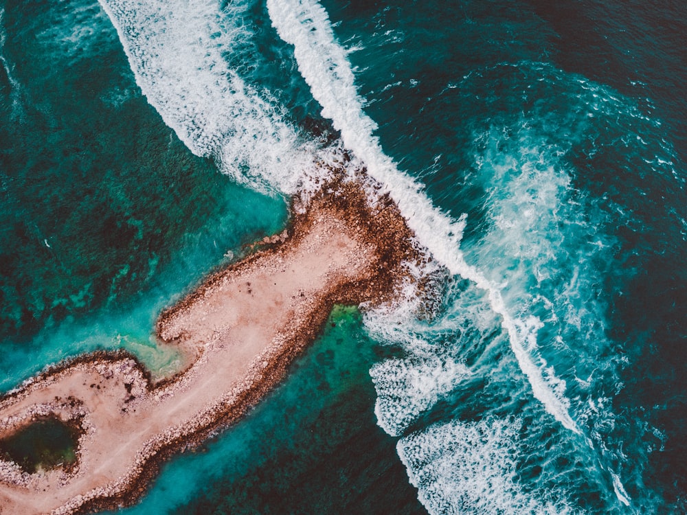 Île brune entourée d’eau de mer pendant la journée