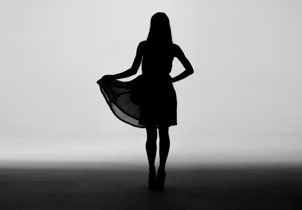 silhouette of woman holding skirt of dress