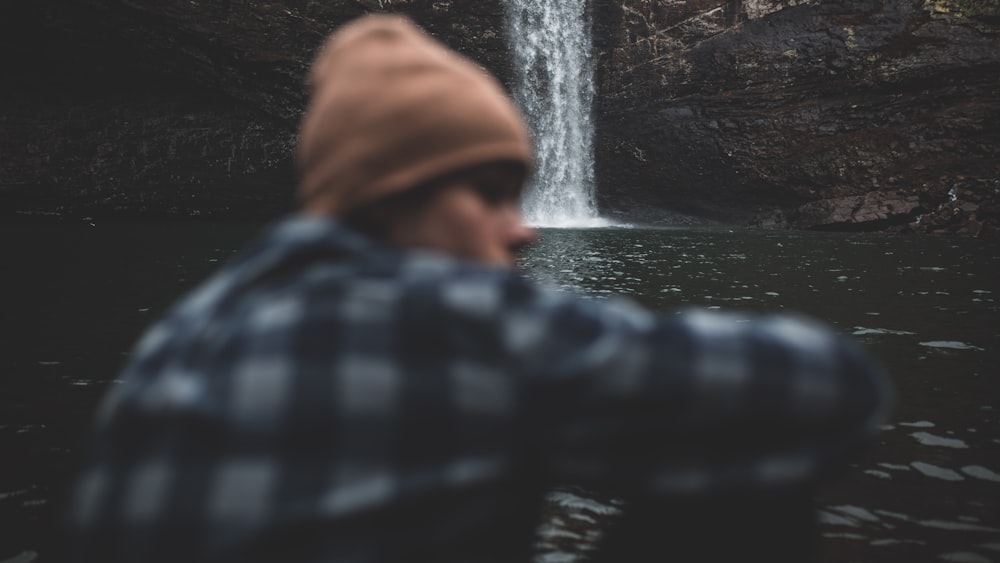 person sitting beside waterfalls
