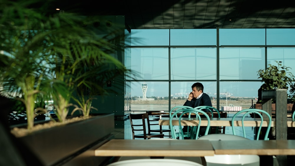 man sitting on chair while using phone