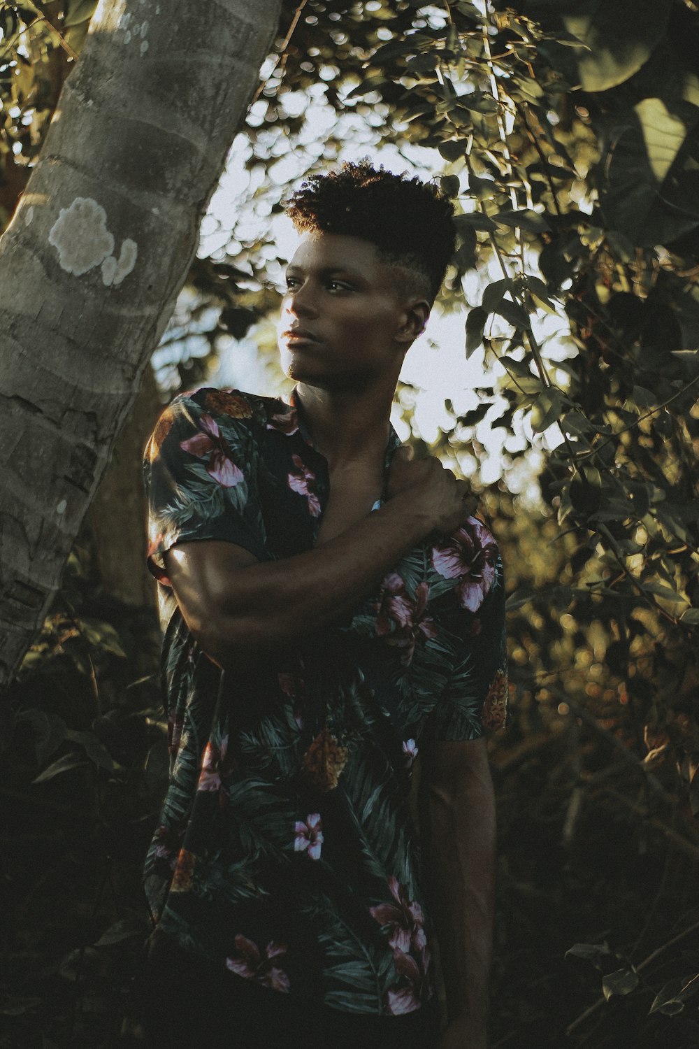 man standing holding shoulder near the coconut tree