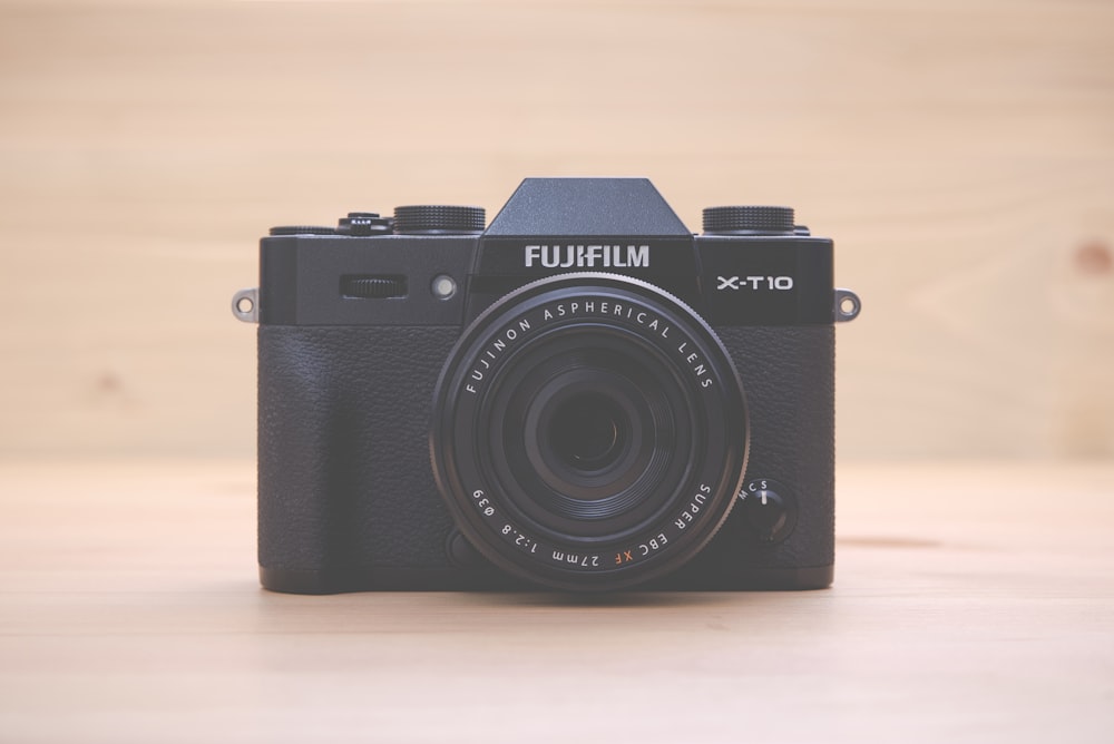 fotocamera point-and-shoot Fujifilm X-T-HD nera su superficie marrone