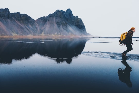 person standing on body of water in Stokksnes Iceland