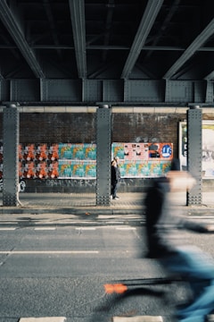 time lapse photo of man riding on bike on road