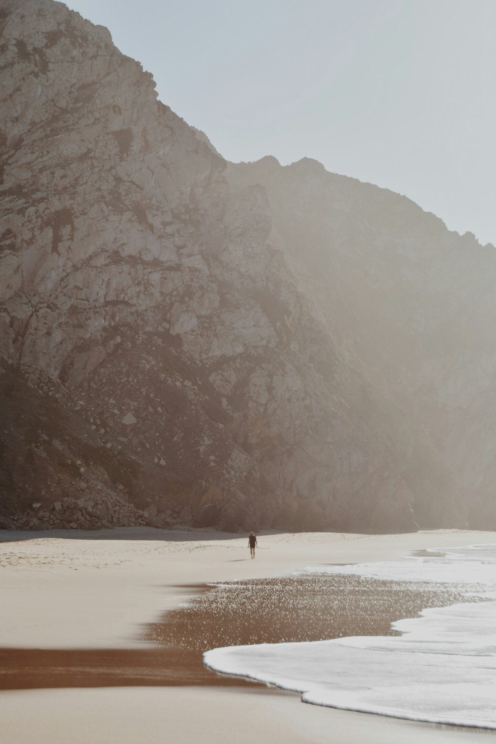 person walking seaside during daytime