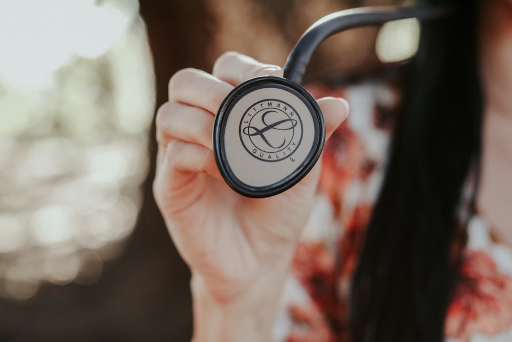 a close up of a person holding a compass