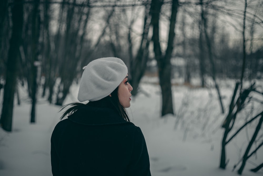 Frau schaut nach links und steht im Schnee