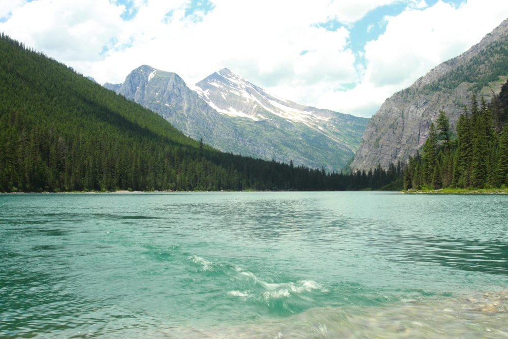 calm body of water near mountain