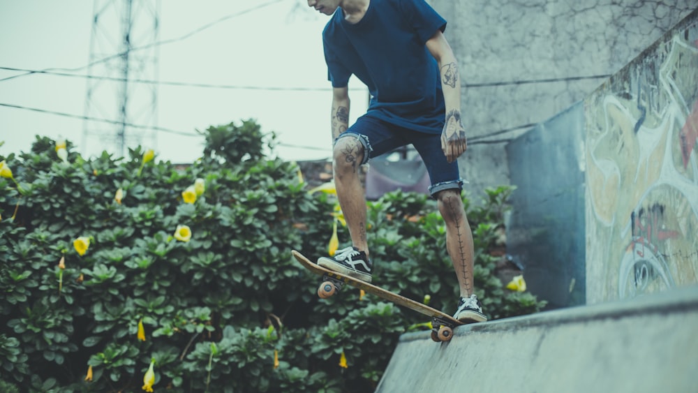 person wearing Vans OS sneakers riding skateboard above ramp