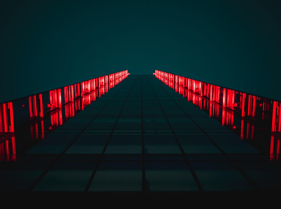 black pathway between red LED light rails,