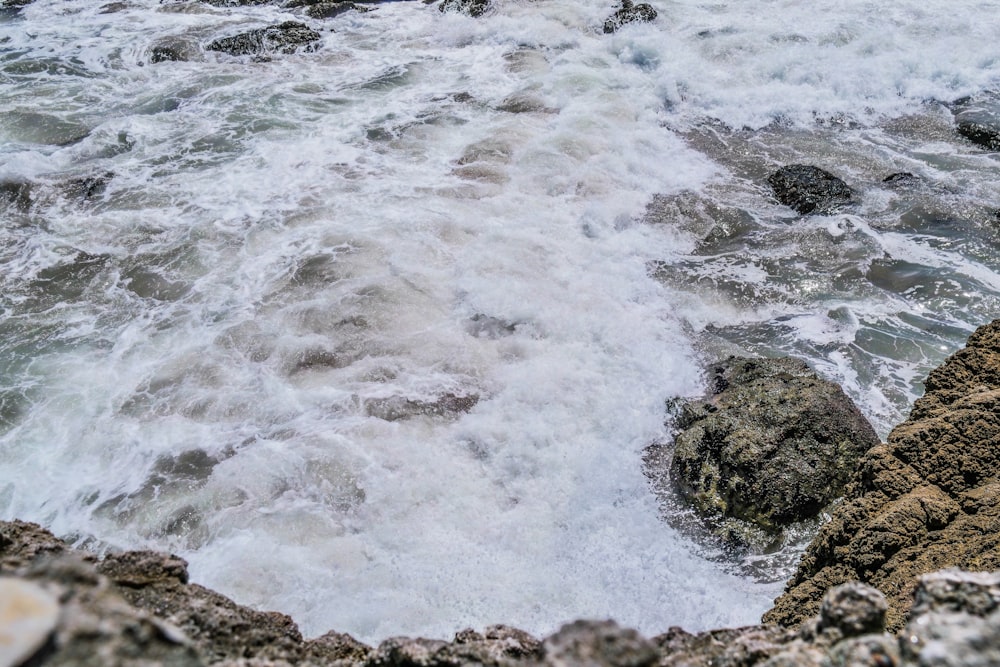 ocean waves crashing on rocks during daytime