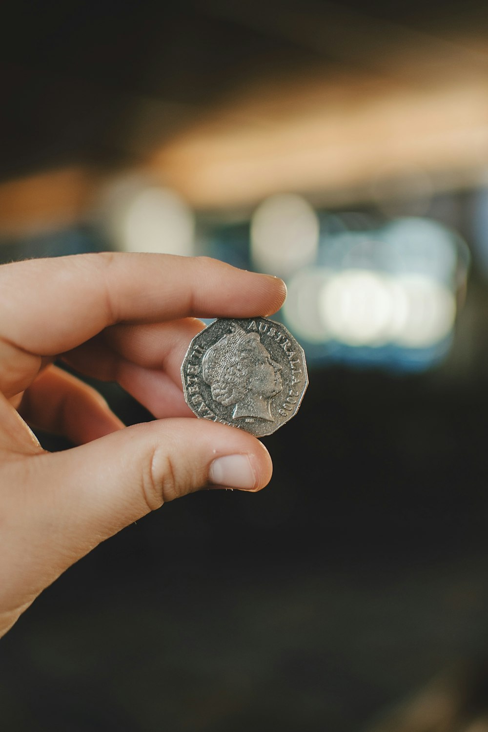 silver round coin on persons hand