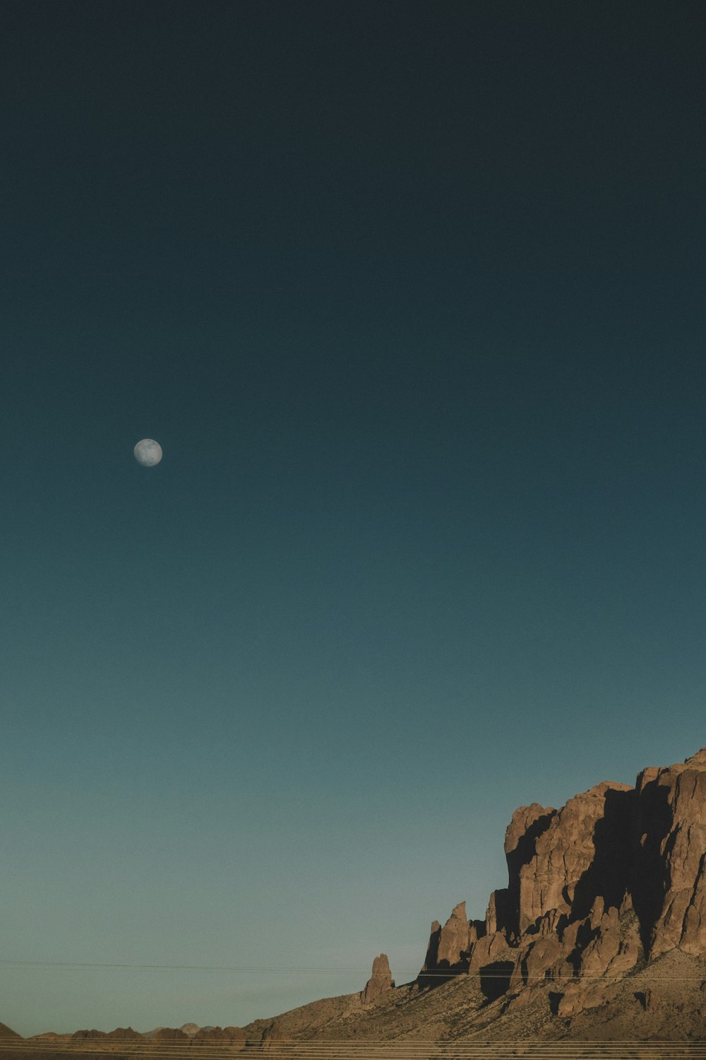 rock formation under clear skies and moon