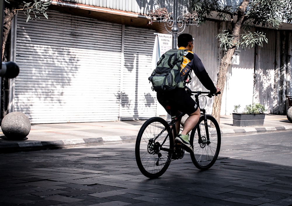 man riding bicycle near shutter roller