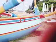 Traditional wooden boats painted bright colors resting on the sandy shores of a quiet Konkan beach.