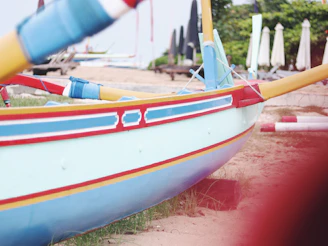 Traditional wooden boats painted bright colors resting on the sandy shores of a quiet Konkan beach.