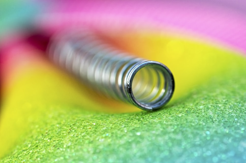 gray metal spring on yellow and green textile