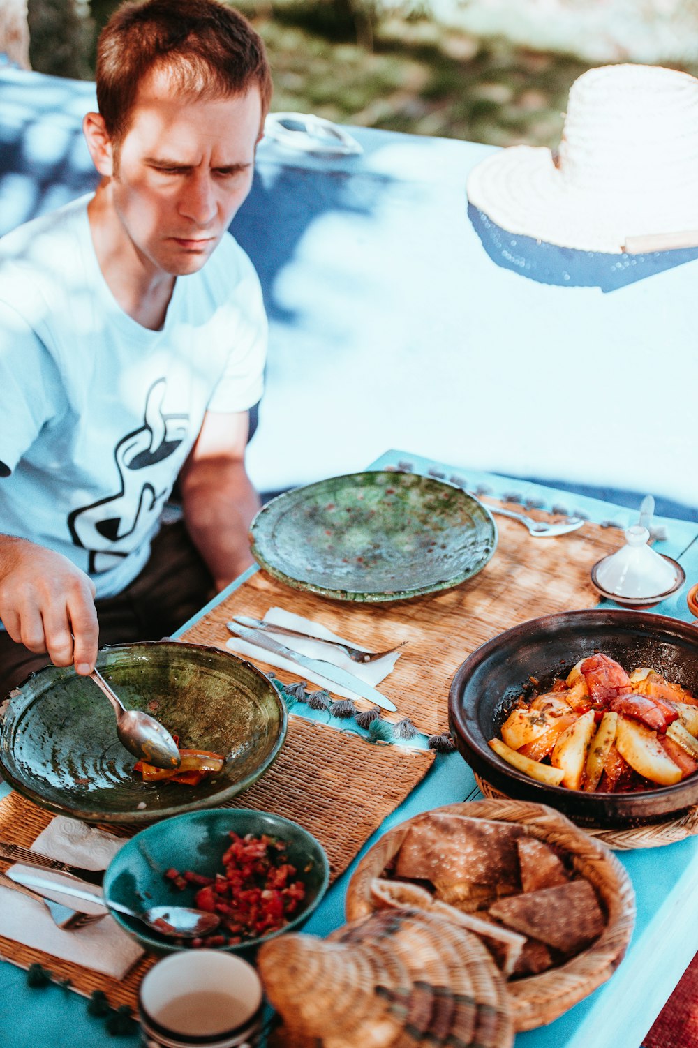 man holding spoon with foods on table