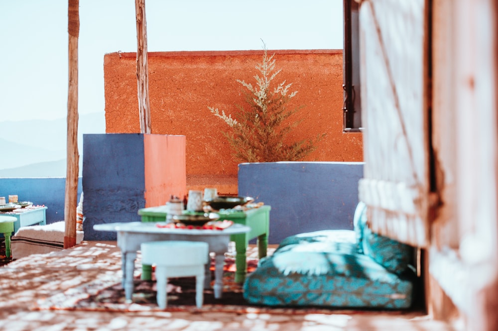 two white and green tables beside cushions