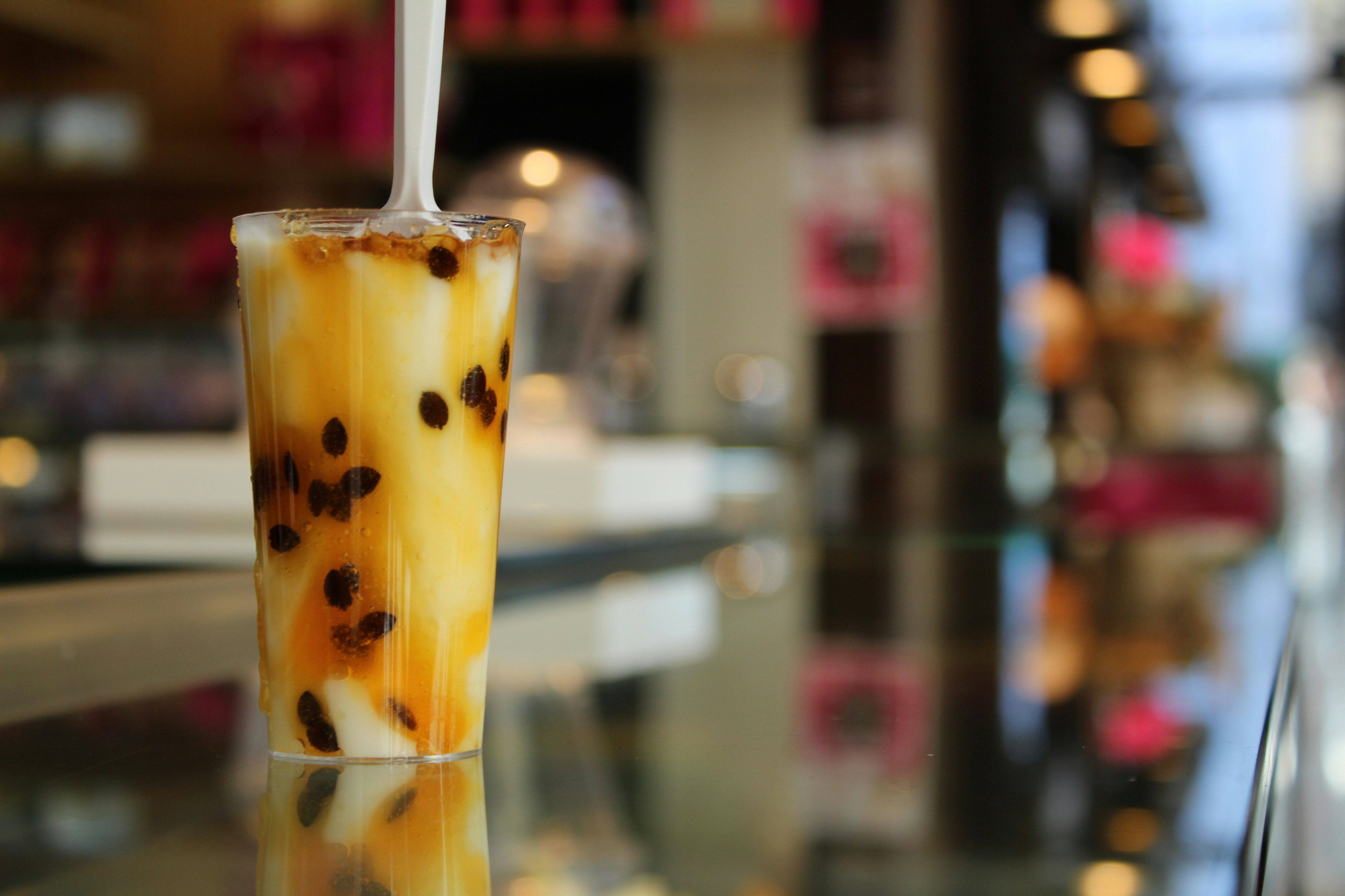 Colorful boba milk tea with tapioca pearls in a glass, pastel colors, modern café