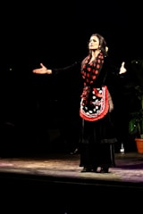 Zaza Gagua performing on stage in a dramatic opera costume under spotlight.