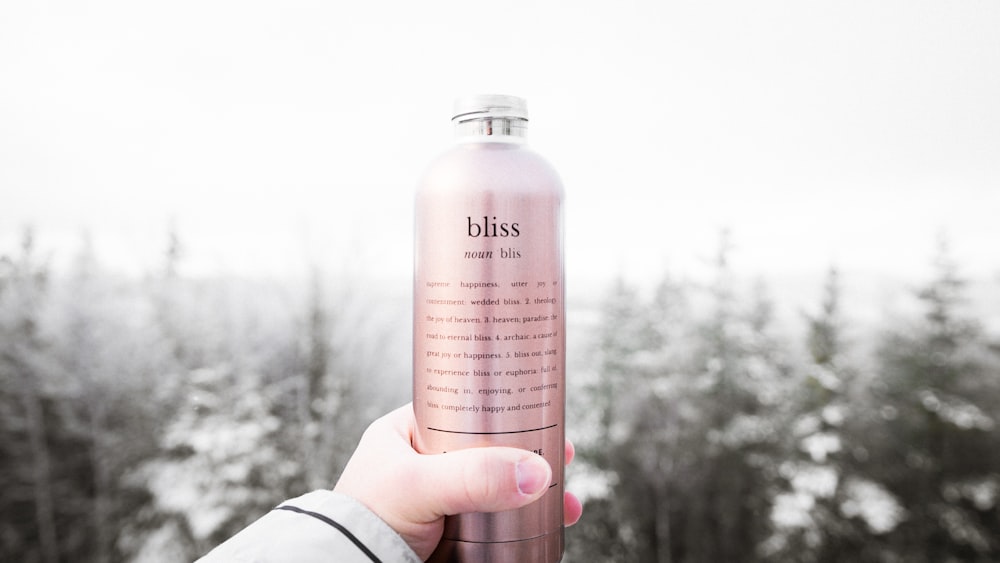 Person mit Bliss Lotion Flasche