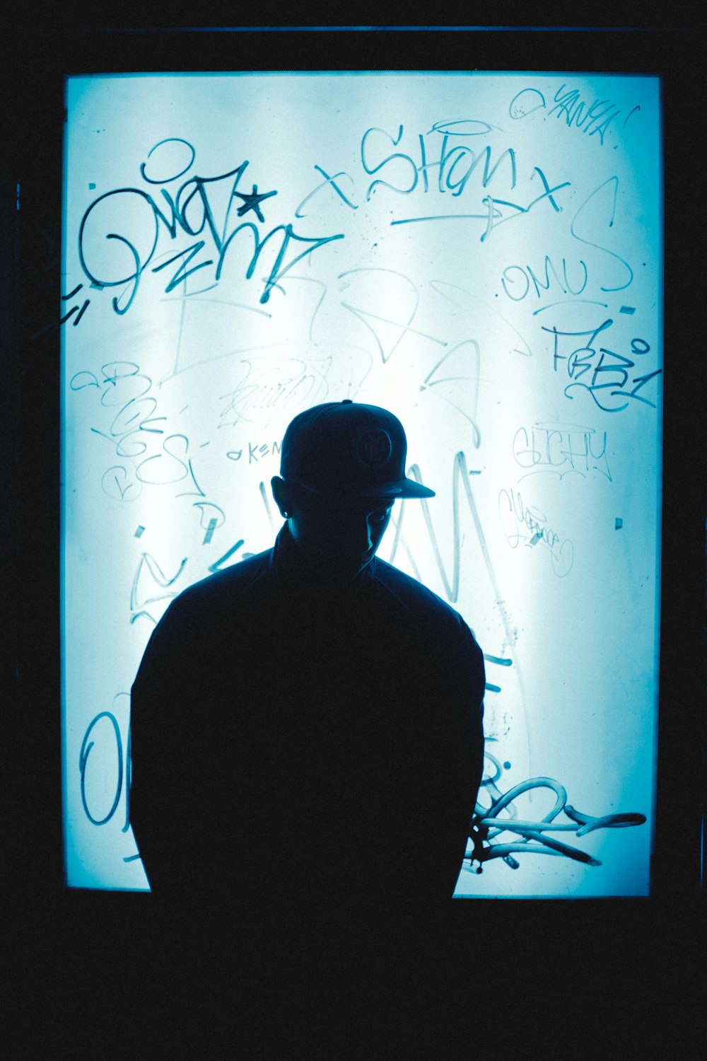 silhouette of man in front of signed poster