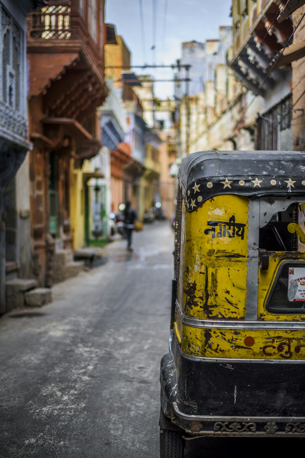 Fotografía de enfoque selectivo de rickshaw automático amarillo en la carretera