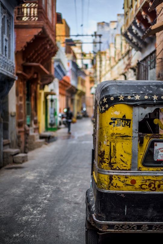 selective focus photography of yellow auto rickshaw on road in Jodhpur India
