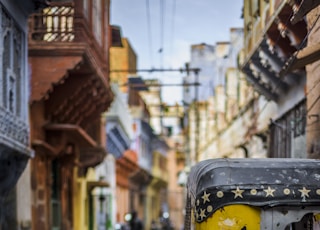 selective focus photography of yellow auto rickshaw on road