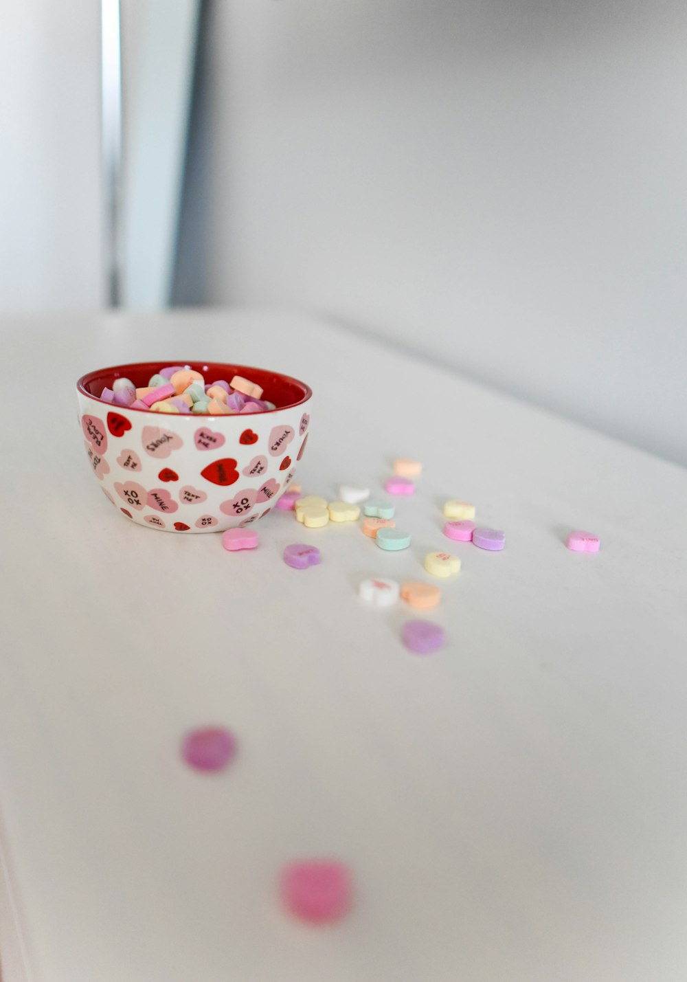 white and red ceramic bowl on white surface