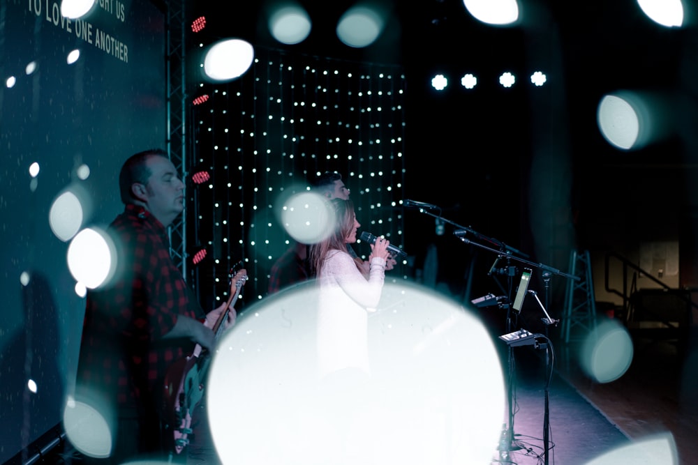 woman singing and man playing guitar on stage