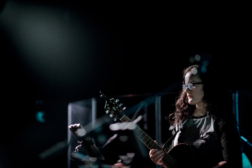 Mujer tocando la guitarra en el escenario