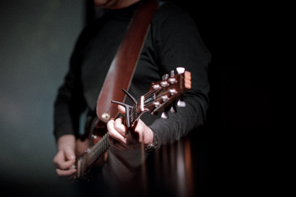 person playing brown guitar