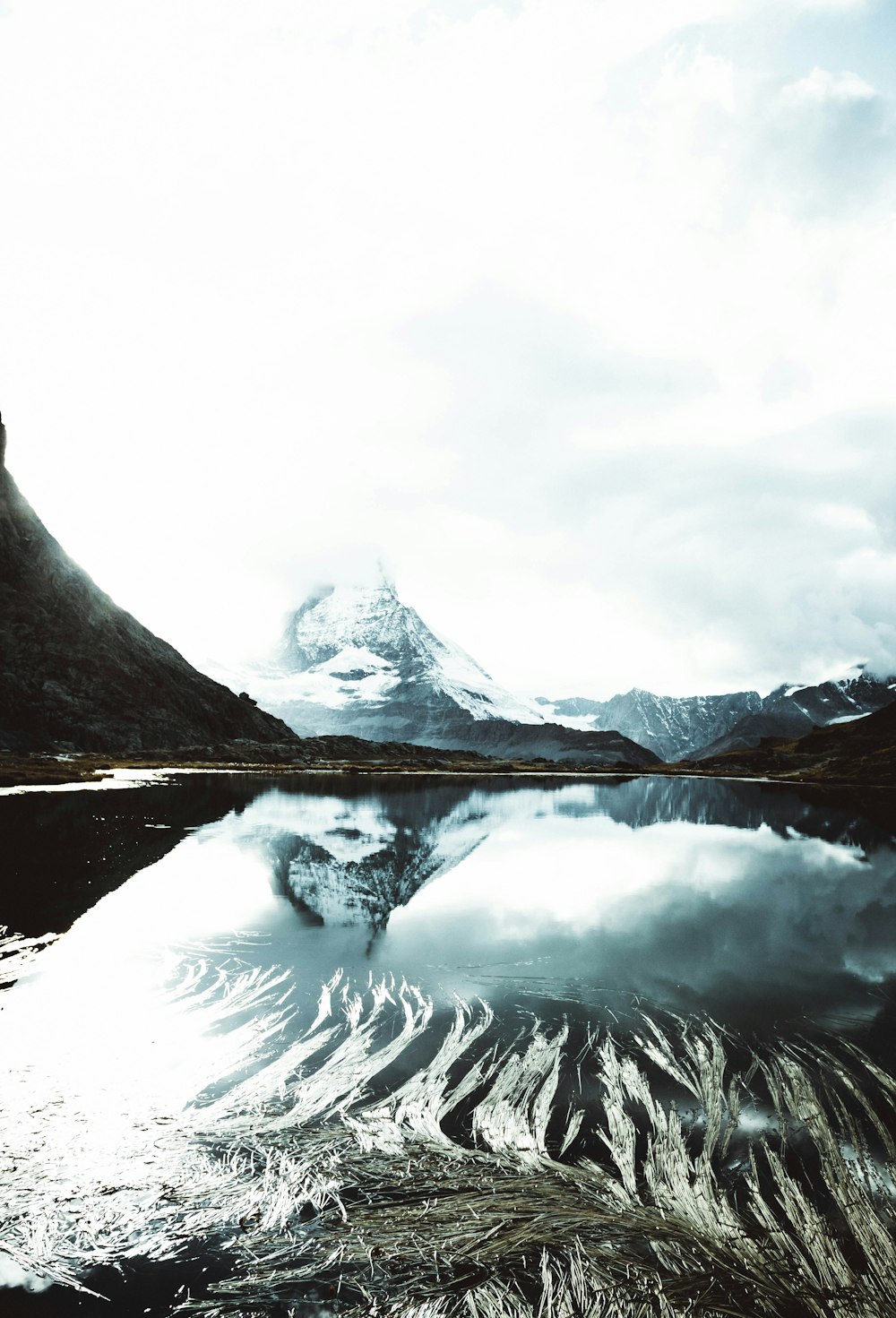 mountain covered with snow under white sky