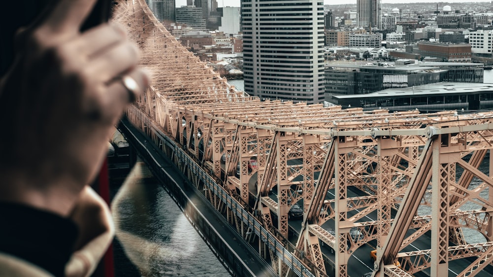 black and brown concrete bridge near city buildings