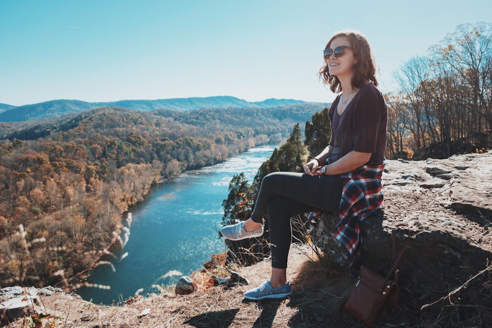 woman sitting on rocks during daytime