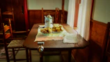 Sunlit breakfast nook with rustic wooden table set for morning coffee and pastries.