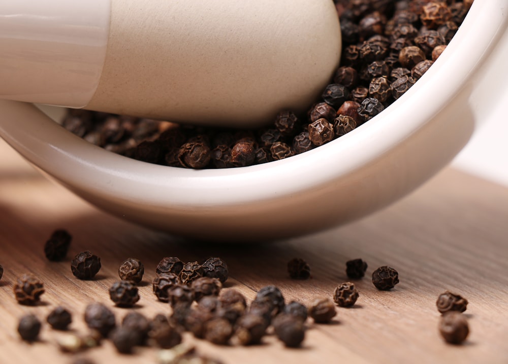 black pepper on white ceramic mortar and pestle