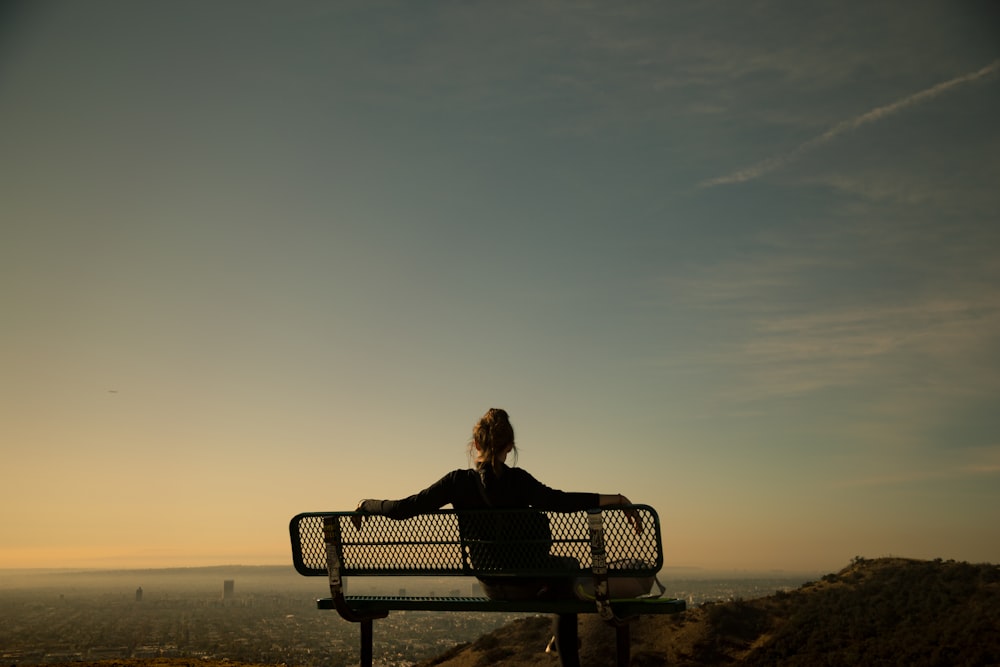 femme assise sur un banc pendant la journée