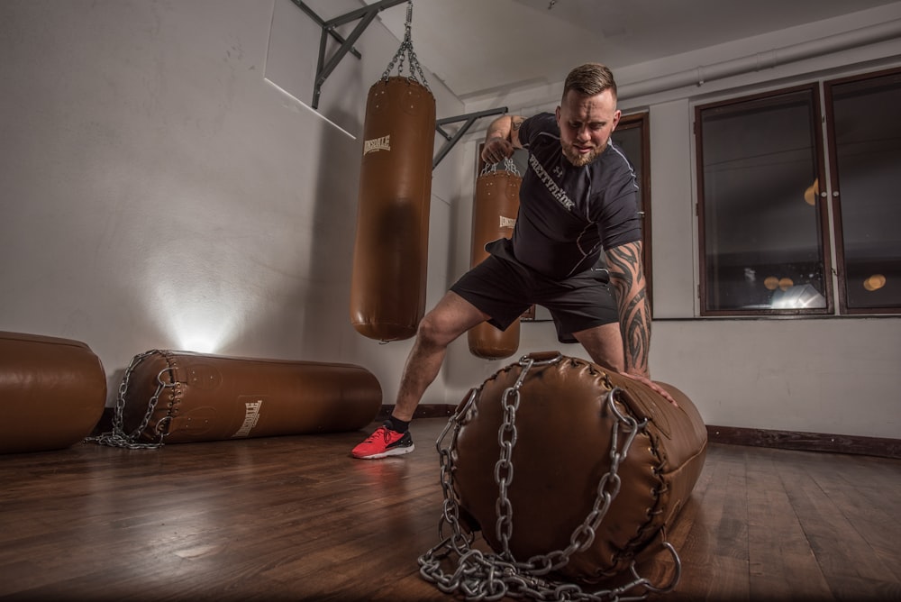 man punching brown leather heavy bag