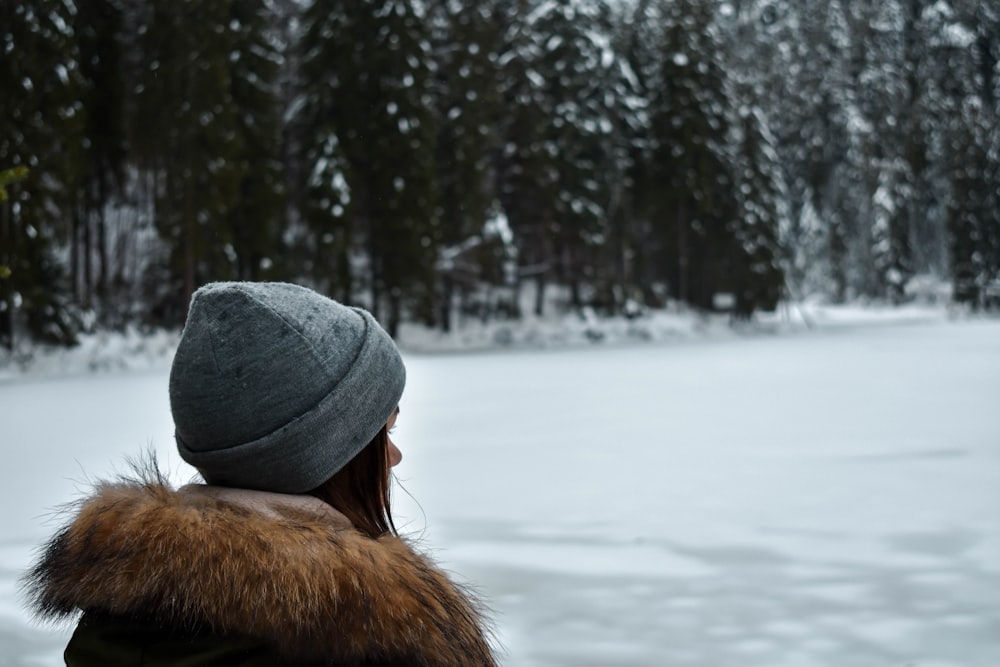 woman standing near snow-covered trees