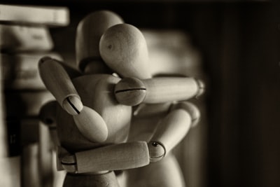 two wooden dummy hugging figures hug google meet background