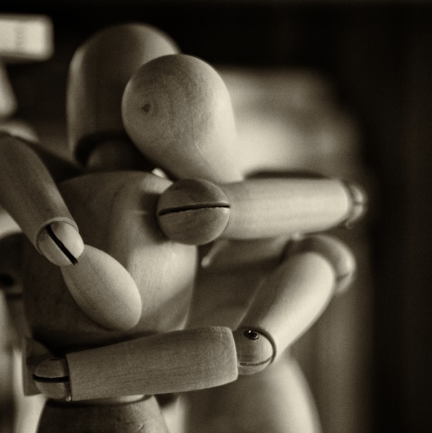 two wooden dummy hugging figures