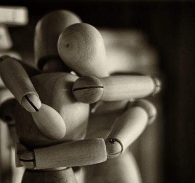 two wooden dummy hugging figures